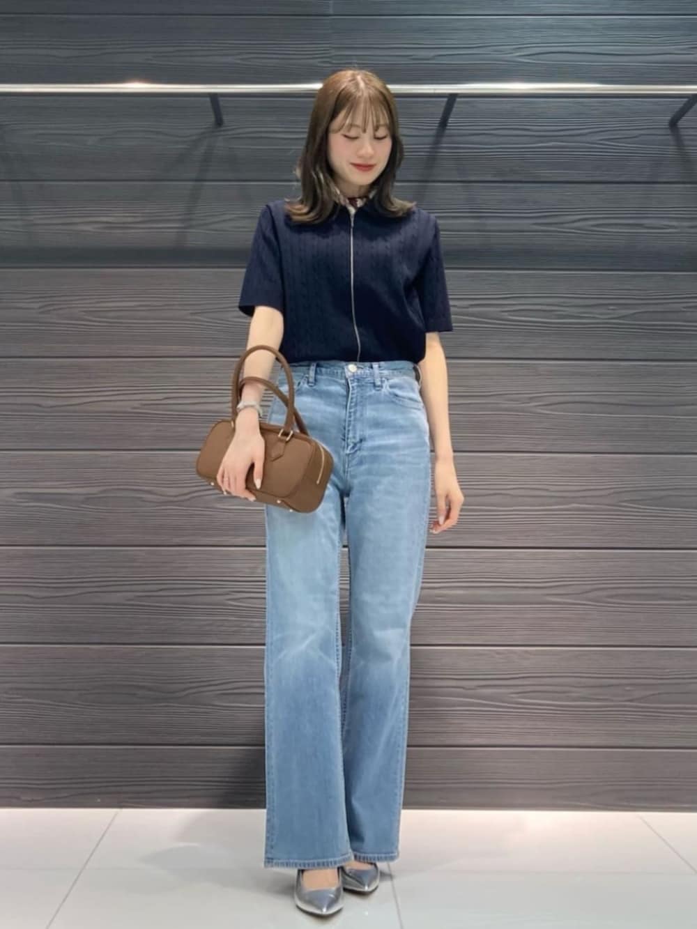 ブルー系のデニムパンツ、ブルー系のカーディガン/ボレロ、ブラウン系のボストンバッグを着用したレディースの春コーディネートの2枚目の写真