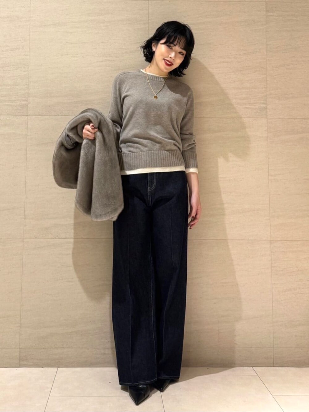 ブルー系のデニムパンツ、ベージュ系のベスト、ブラウン系のニット/セーターを着用したレディースの秋コーディネートの7枚目の写真