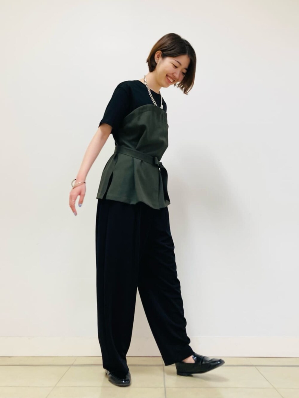 グリーン系のTシャツ/カットソー、ブラック系のパンツを着用したレディースの夏コーディネートの3枚目の写真