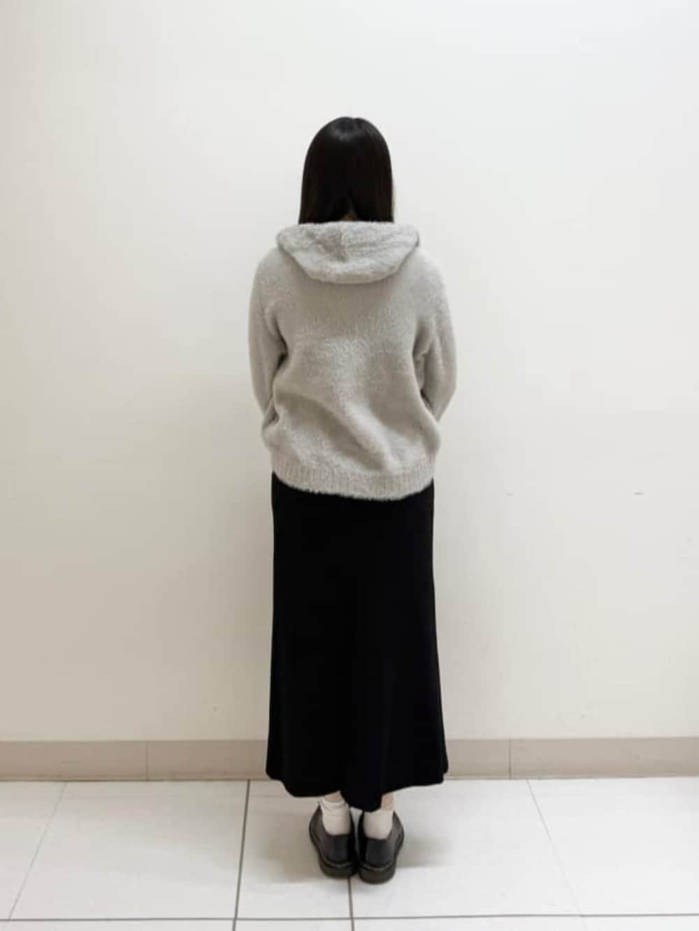 ベージュ系のパーカー、ブラック系のスカート、ブラック系のブルゾンを着用したレディースの冬コーディネートの4枚目の写真