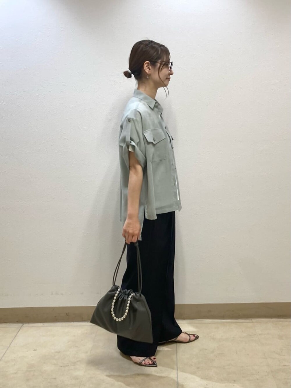 グレー系のシャツ/ブラウス、ブルー系のその他パンツ、グレー系のクラッチバッグを着用したレディースの夏コーディネートの4枚目の写真