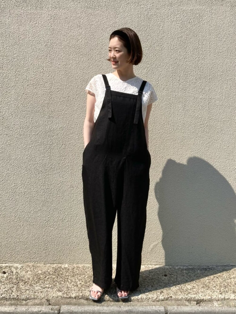 ホワイト系のシャツ/ブラウス、ブラック系のオールインワン・サロペットを着用したレディースの春コーディネートの3枚目の写真