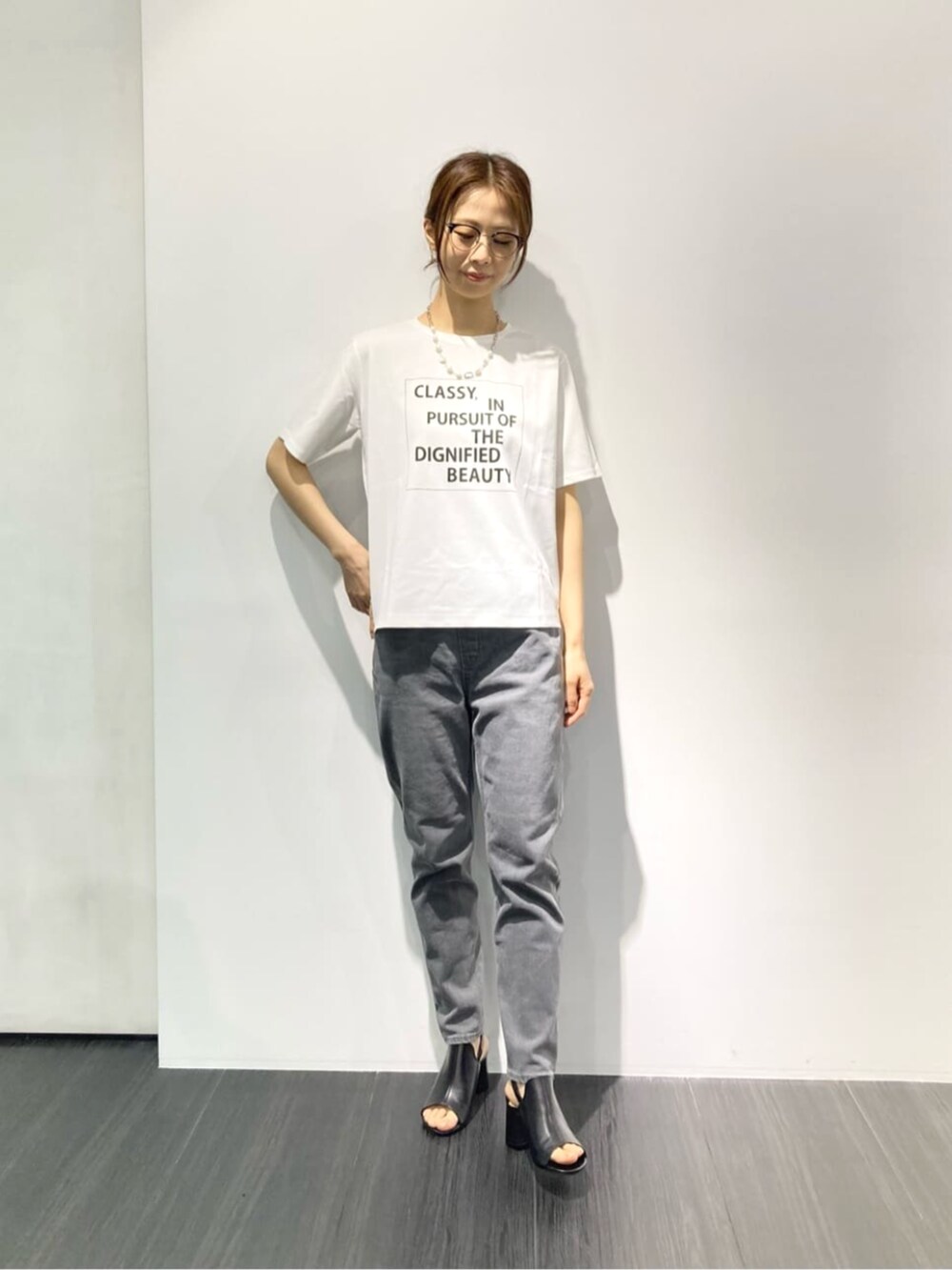 ホワイト系のTシャツ/カットソー、グレー系のテーラードジャケット、ブラック系のサンダルを着用したレディースの春コーディネートの4枚目の写真