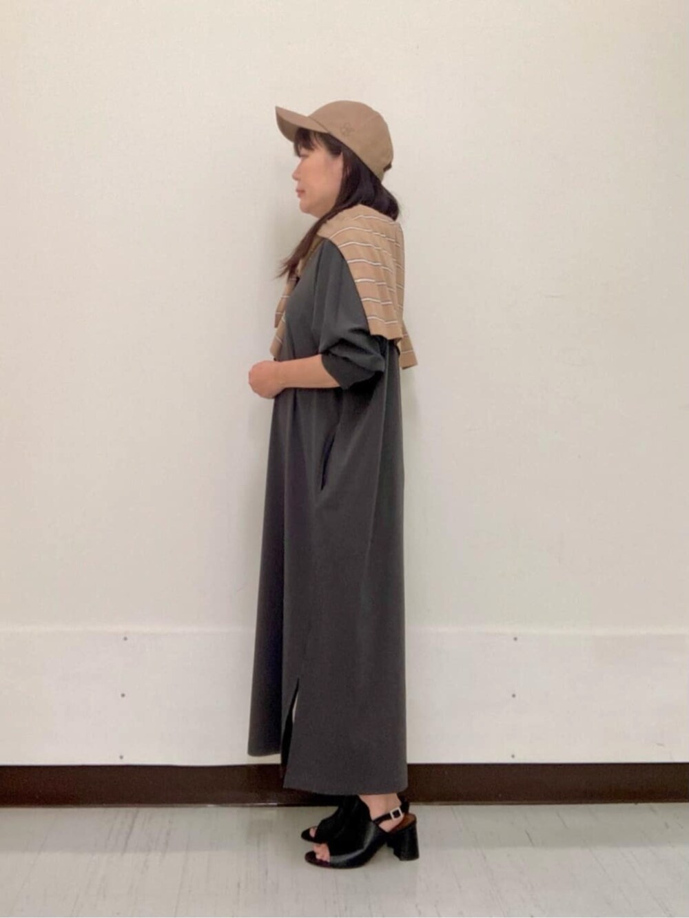 ブラック系のサンダル、グレー系のワンピースを着用したレディースの夏コーディネートの3枚目の写真