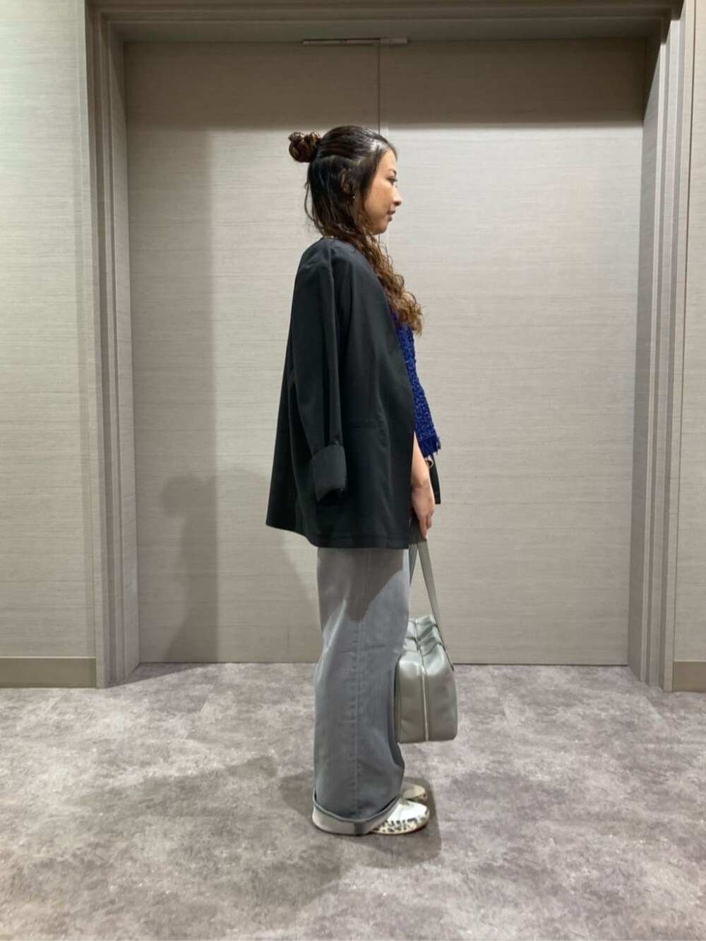 ブルー系のニット/セーター、グレー系のデニムパンツを着用したレディースの夏コーディネートの2枚目の写真