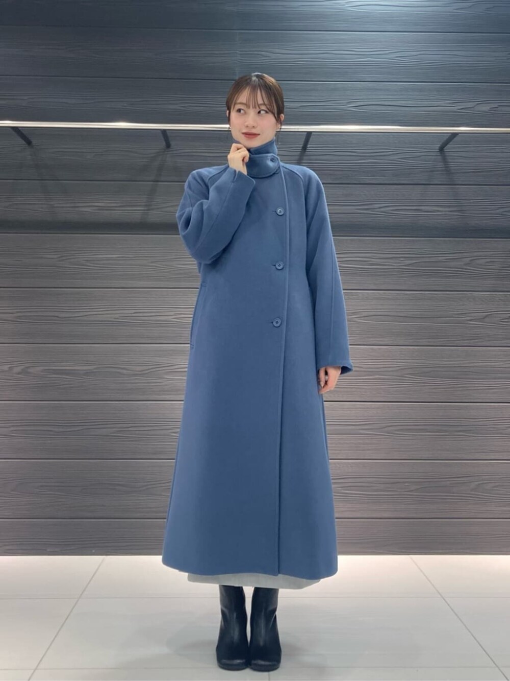 ブルー系のトレンチコート、グレー系のスカート、グレー系のニット/セーターを着用したレディースの冬コーディネートの3枚目の写真