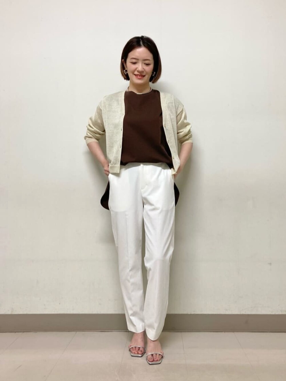 イエロー系のカーディガン/ボレロ、ブラウン系のTシャツ/カットソー、ホワイト系のパンツを着用したレディースの春コーディネートの5枚目の写真