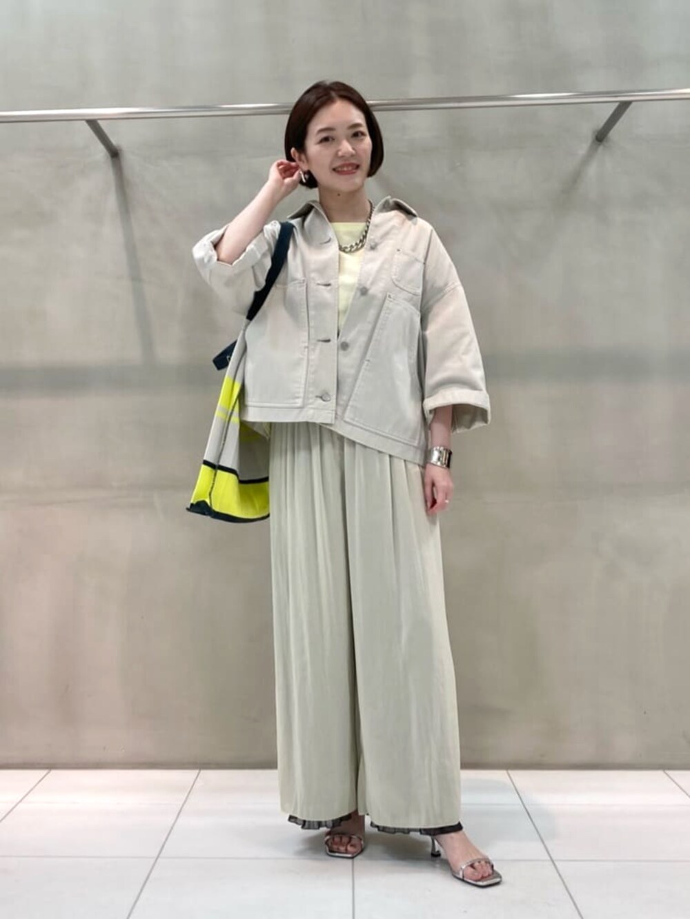 グレー系のシャツ/ブラウス、グレー系のその他パンツ、イエロー系のトートバッグを着用したレディースの春コーディネートの2枚目の写真