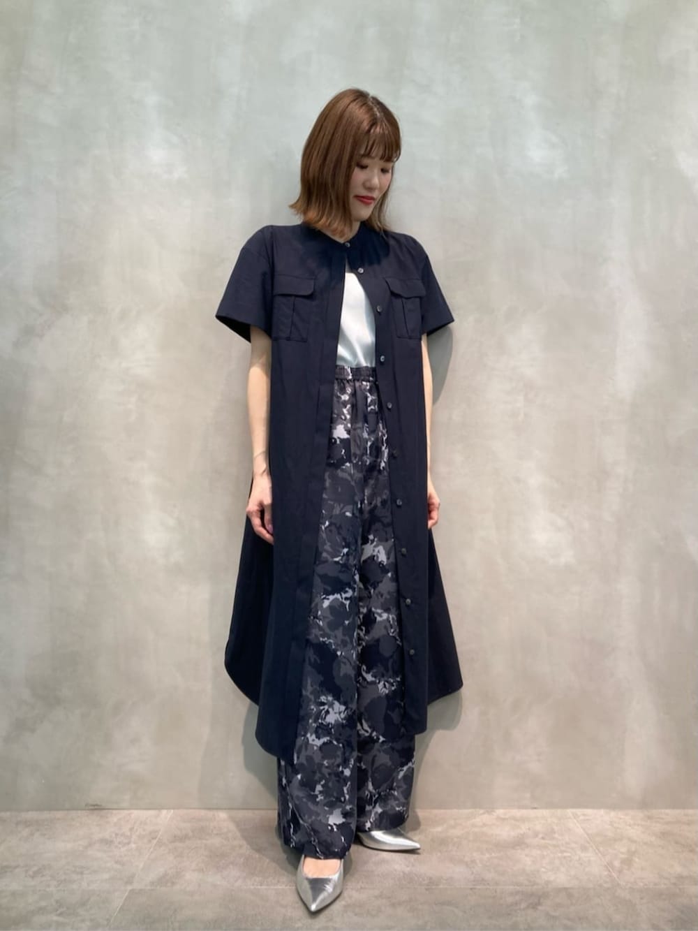 シルバー系のパンプス、ホワイト系のタンクトップ、ブルー系のその他パンツを着用したレディースの春コーディネートの2枚目の写真