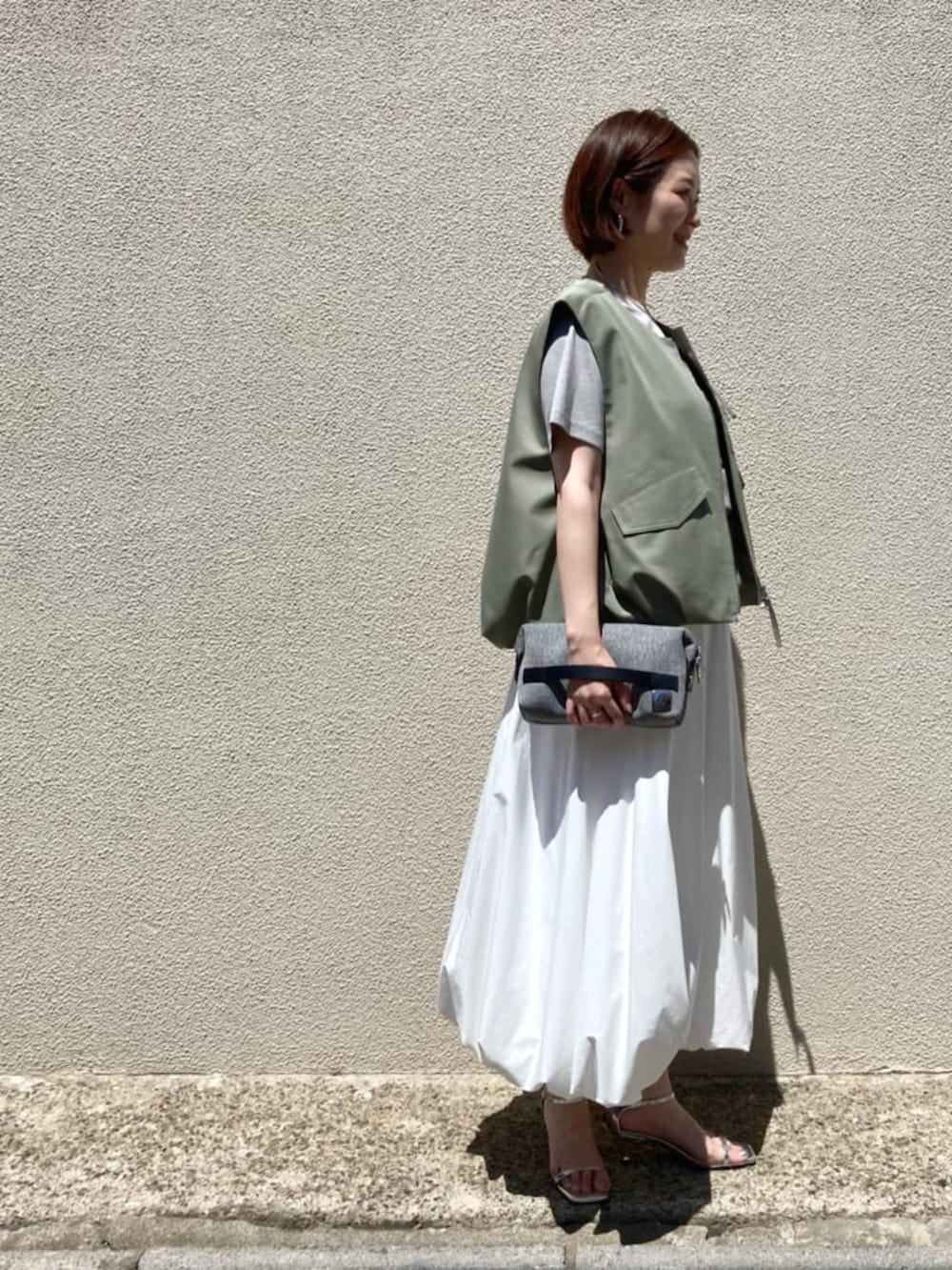 ホワイト系のスカート、ベージュ系のTシャツ/カットソーを着用したレディースの夏コーディネートの6枚目の写真