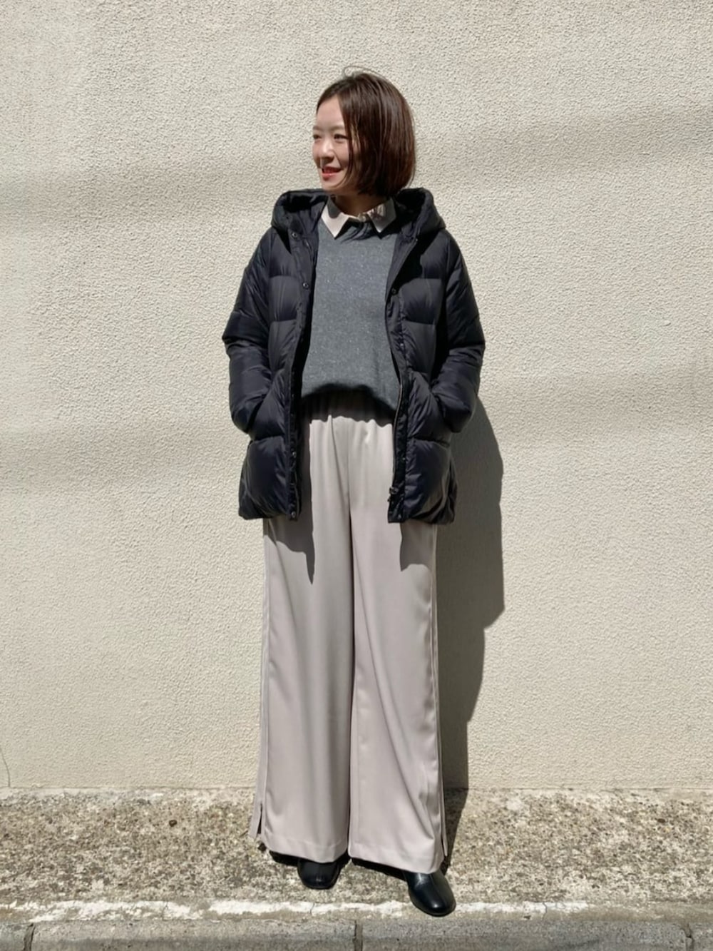 ブラック系のダウンジャケット/コート、ベージュ系のその他パンツ、グレー系のTシャツ/カットソーを着用したレディースの冬コーディネートの2枚目の写真