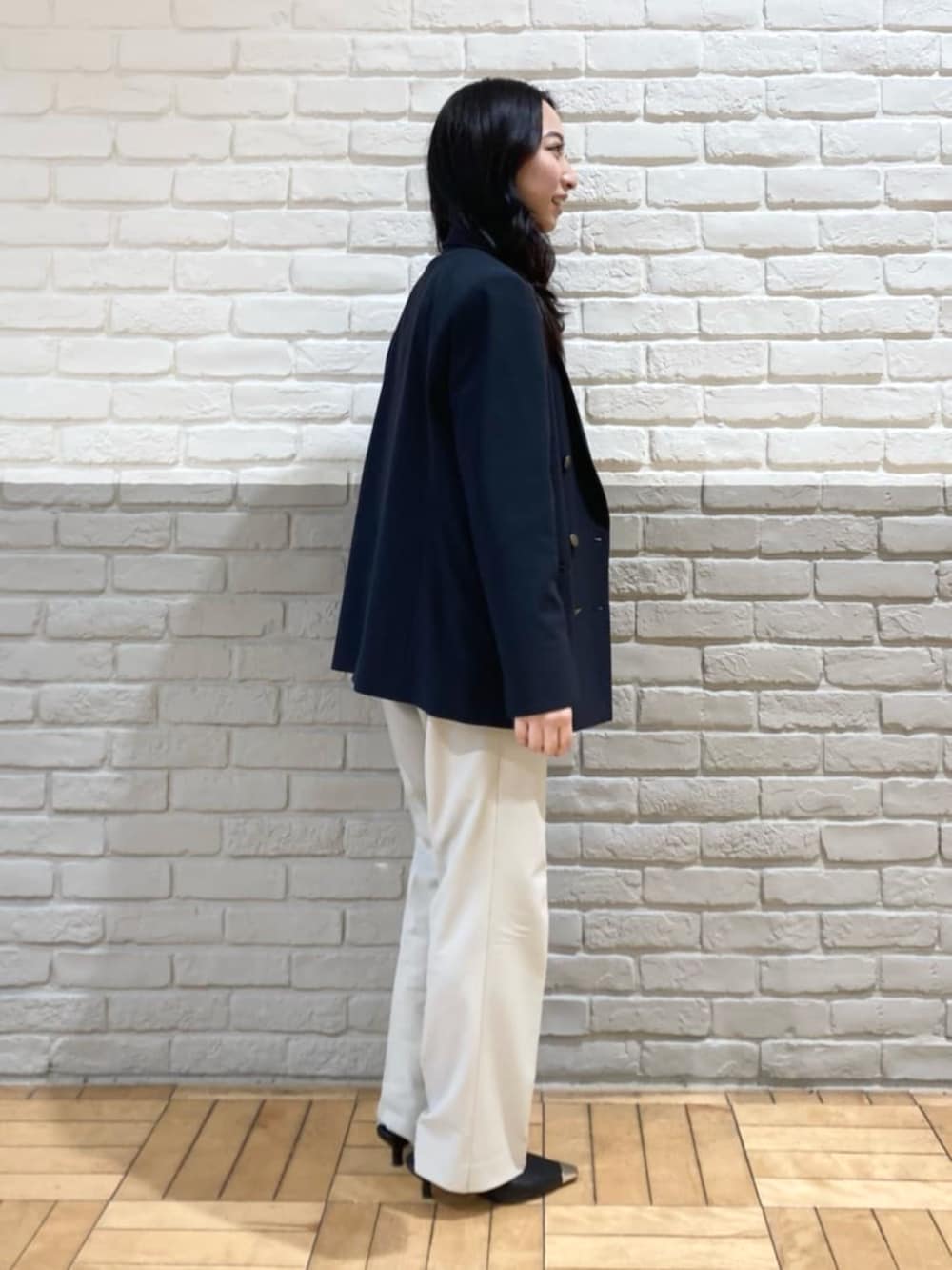 ブルー系のセットアップ、ホワイト系のニット/セーター、ベージュ系のその他パンツを着用したレディースの春コーディネートの2枚目の写真