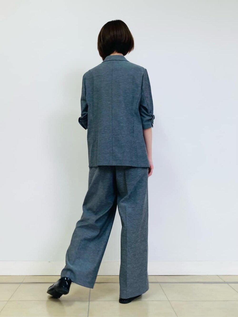 グレー系のテーラードジャケット、グレー系のその他パンツ、ホワイト系のシャツ/ブラウスを着用したレディースの秋コーディネートの5枚目の写真