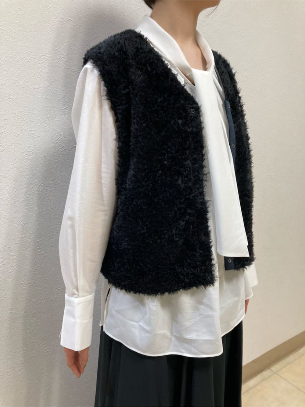 ブラック系のスカート、ブラック系のパンプス、ブルー系のブルゾンを着用したレディースの冬コーディネートの8枚目の写真