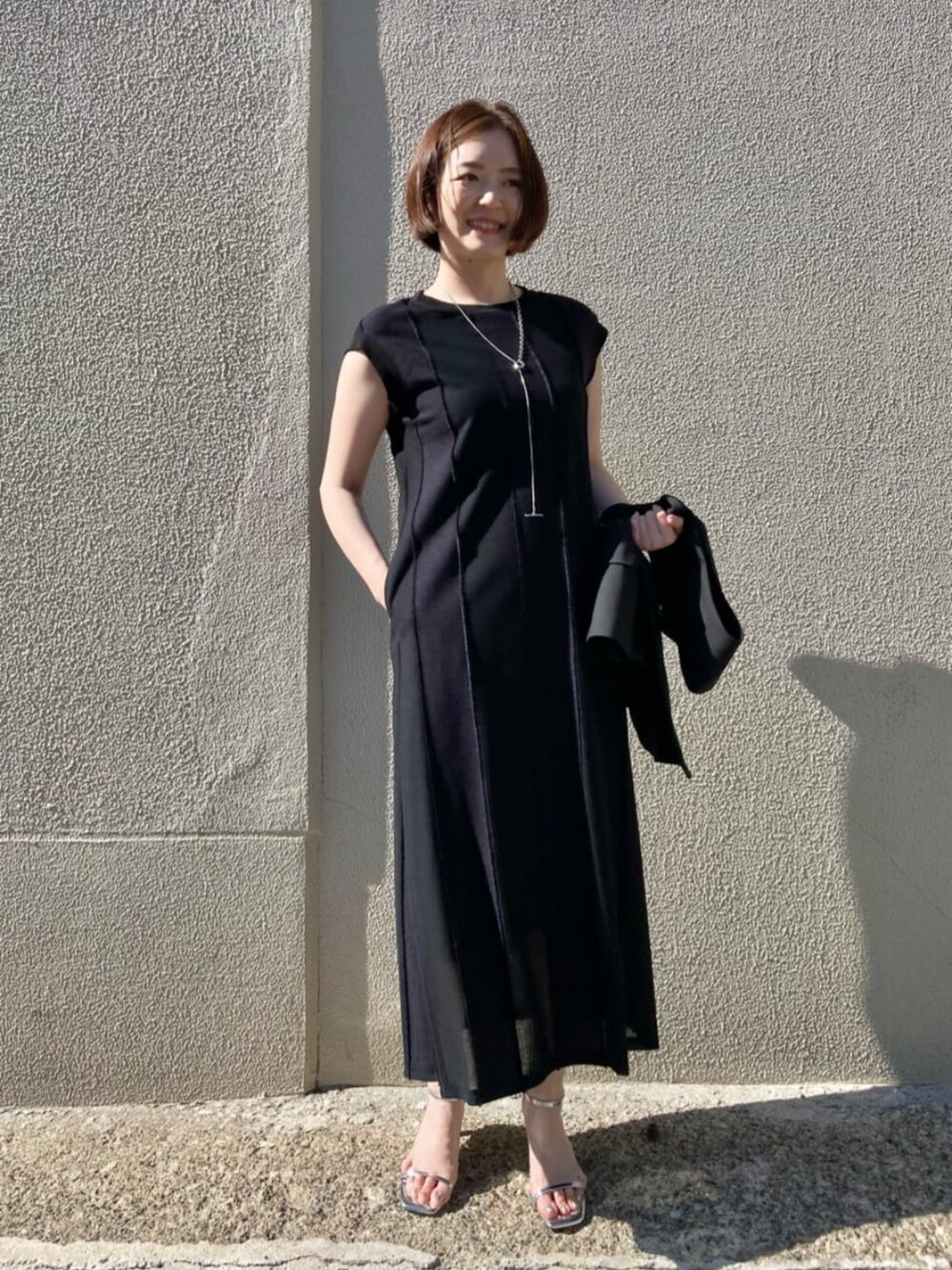 ブラック系のベストを着用したレディースの夏コーディネートの5枚目の写真