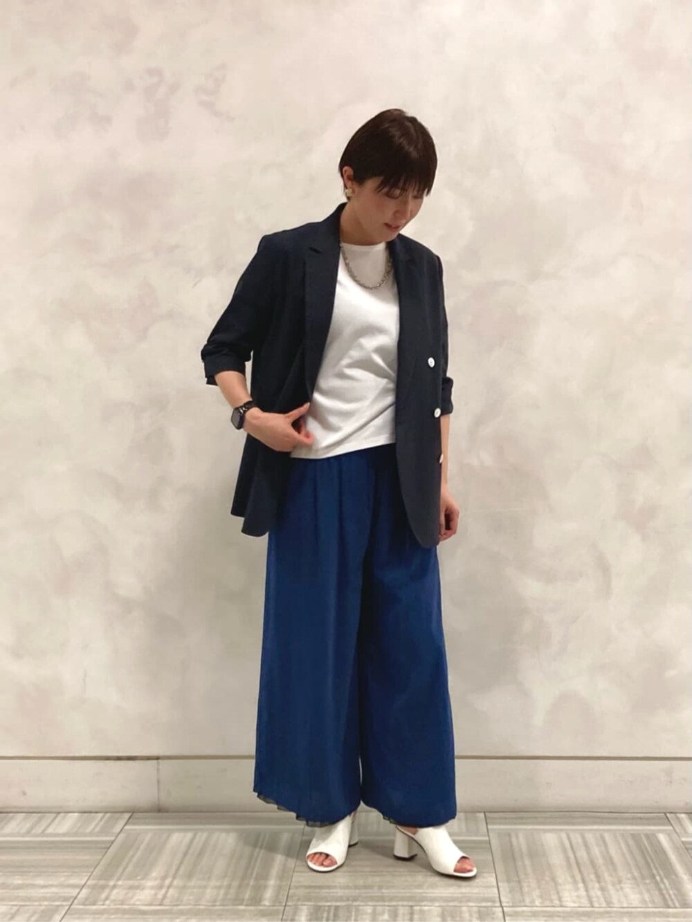 ホワイト系のサンダル、ホワイト系のTシャツ/カットソー、ブルー系のその他パンツを着用したレディースの夏コーディネートの2枚目の写真