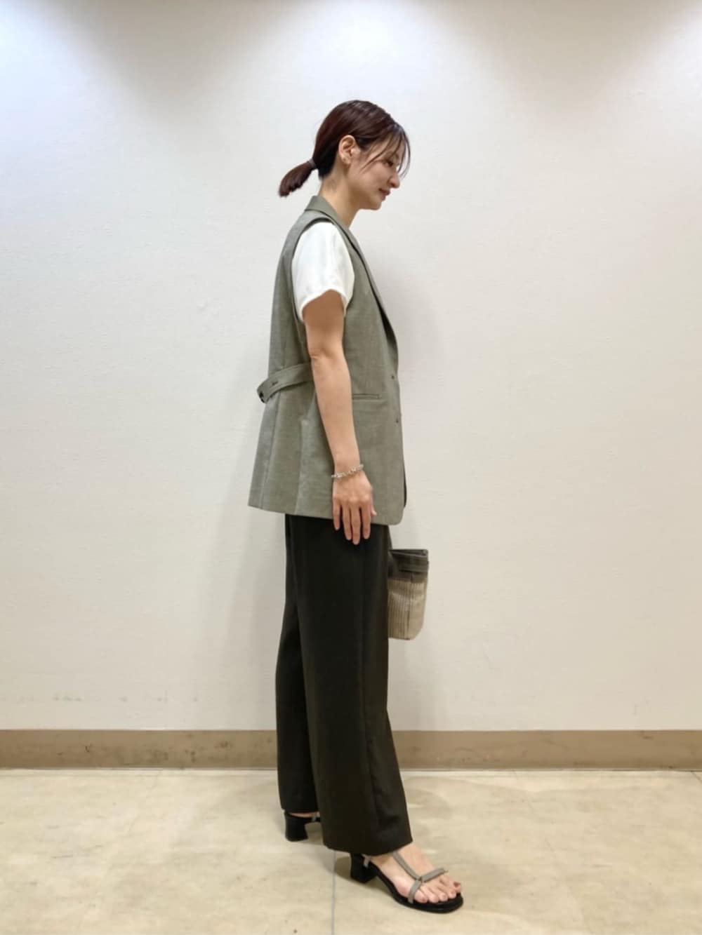 ベージュ系のベスト、ブラウン系のその他パンツ、ホワイト系のTシャツ/カットソーを着用したレディースの春コーディネートの3枚目の写真