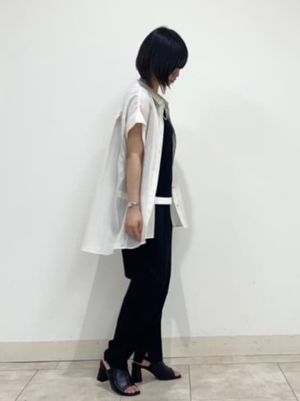 ブラック系のサンダル、ブラック系のその他パンツ、ホワイト系のシャツ/ブラウスを着用したレディースの夏コーディネートの3枚目の写真