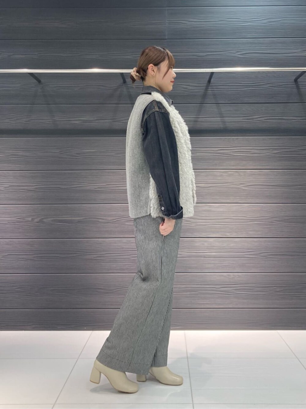 グレー系のベスト、ブラック系のその他パンツ、ブラック系のシャツ/ブラウスを着用したレディースの秋コーディネートの3枚目の写真