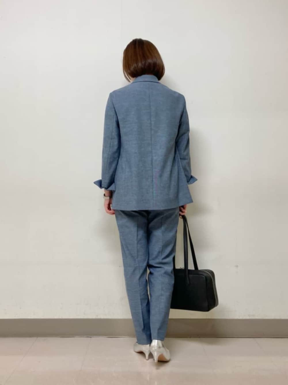 ブルー系のテーラードジャケット、ブルー系のその他パンツ、ブラック系のボストンバッグを着用したレディースの春コーディネートの5枚目の写真