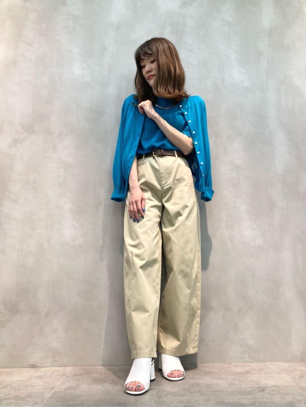 ベージュ系のチノパンツ、ホワイト系のサンダル、グリーン系のニット/セーターを着用したレディースの夏コーディネートの3枚目の写真