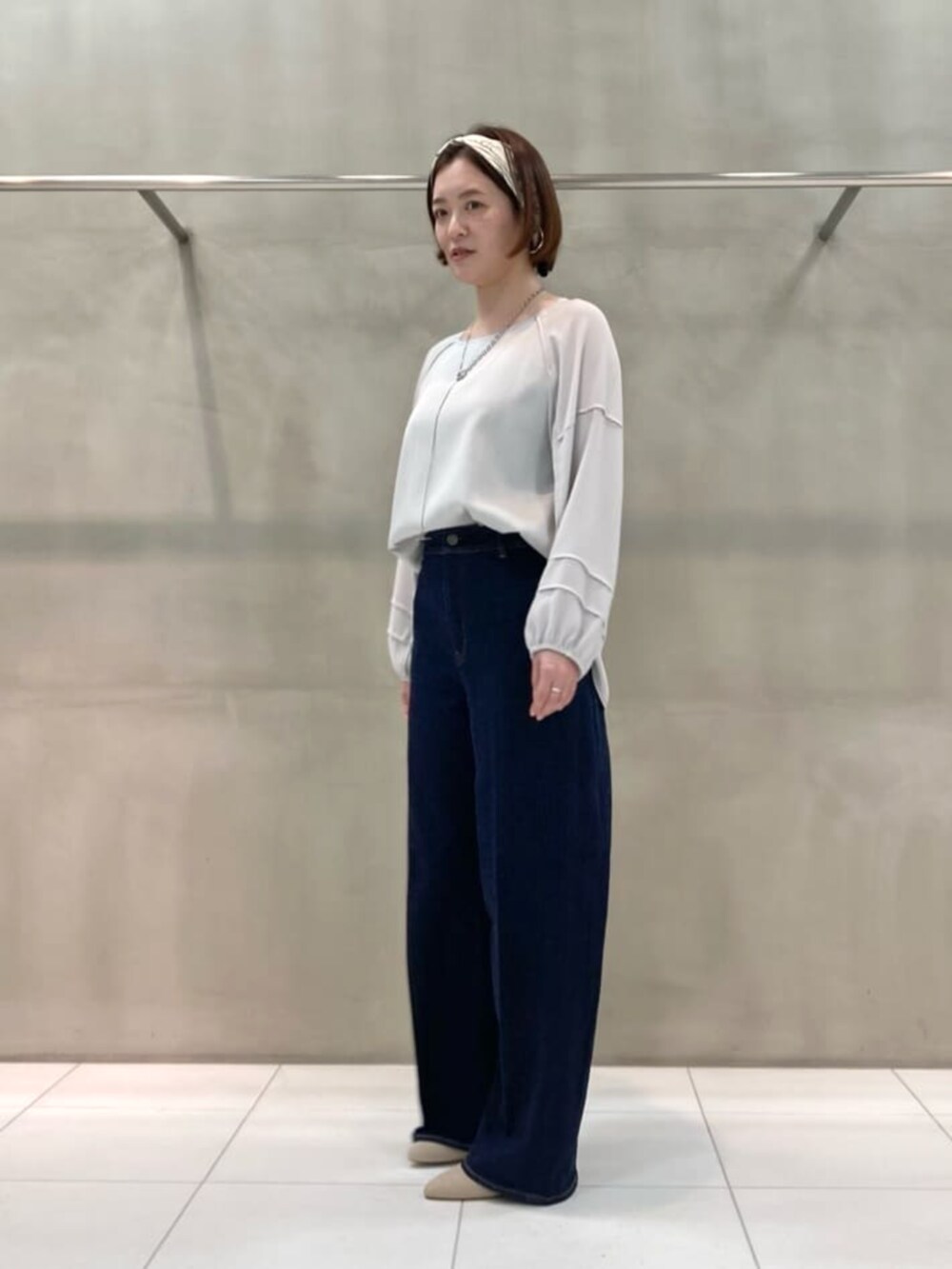 ブルー系のデニムパンツ、グレー系のシャツ/ブラウス、ブラウン系のストール/ショールを着用したレディースの春コーディネートの3枚目の写真