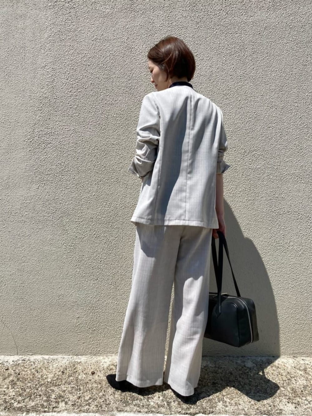 ブルー系のシャツ/ブラウス、ホワイト系のノーカラージャケット、ホワイト系のスラックスを着用したレディースの夏コーディネートの5枚目の写真