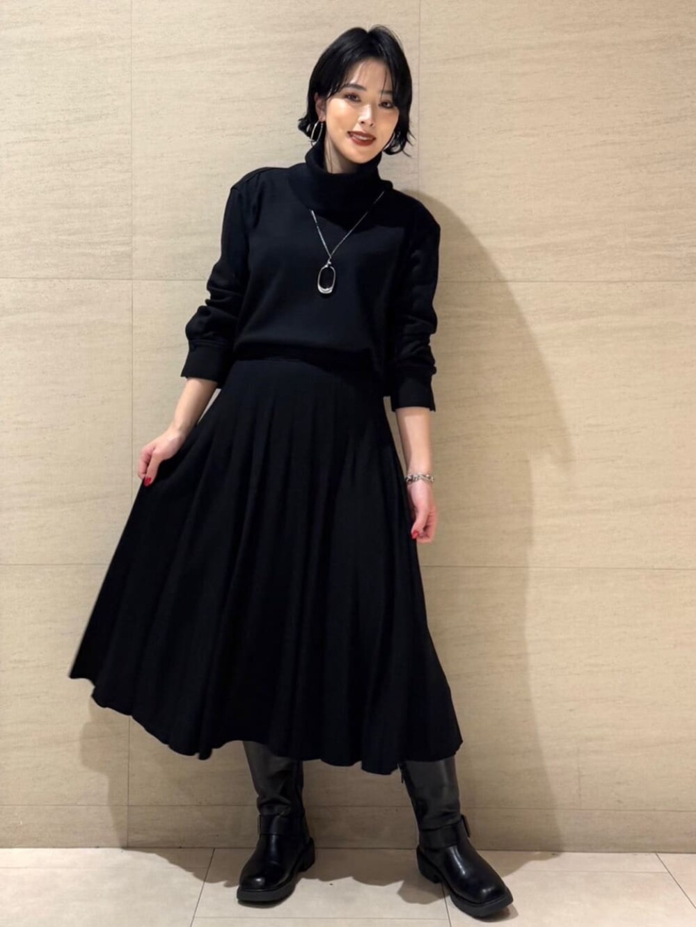 グレー系のブルゾン、ブラック系のTシャツ/カットソー、ブラック系のスカートを着用したレディースの冬コーディネートの6枚目の写真