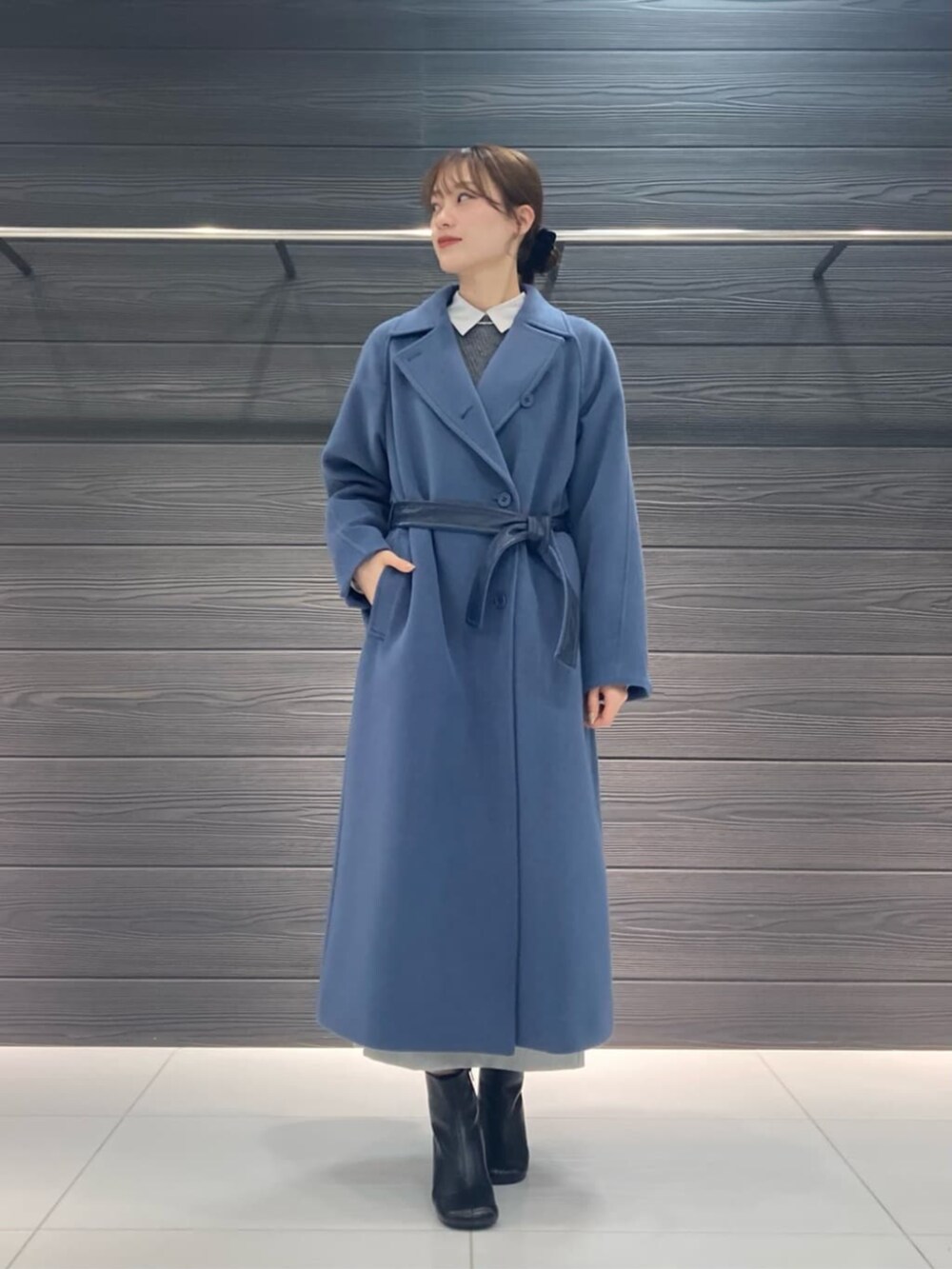 ブルー系のトレンチコート、グレー系のスカート、グレー系のニット/セーターを着用したレディースの冬コーディネートの2枚目の写真