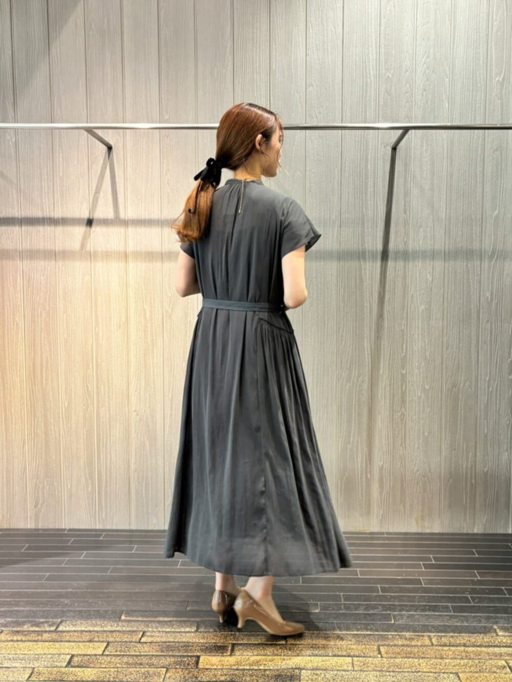 グレー系のワンピース、シルバー系のネックレスを着用したレディースの夏コーディネートの3枚目の写真