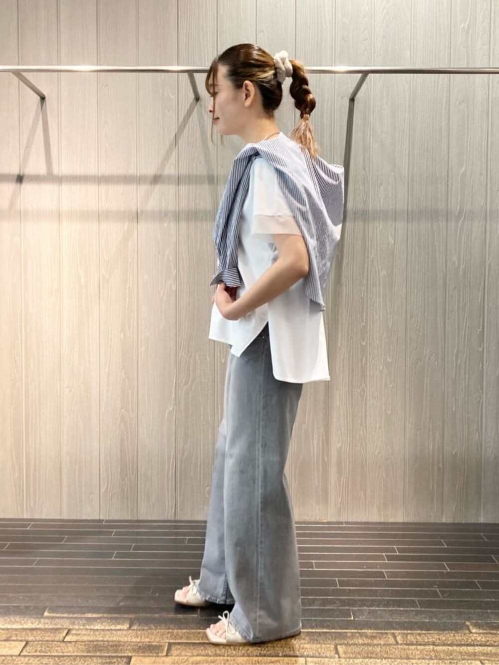 グレー系のデニムパンツ、ブルー系のシャツ/ブラウス、ホワイト系のトップスを着用したレディースの夏コーディネートの4枚目の写真