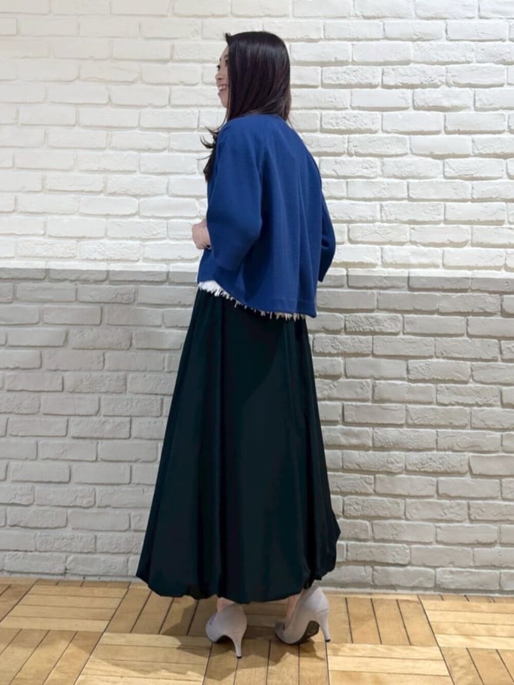 ホワイト系のニット/セーター、ブラック系のスカート、ブルー系のブルゾンを着用したレディースの夏コーディネートの3枚目の写真