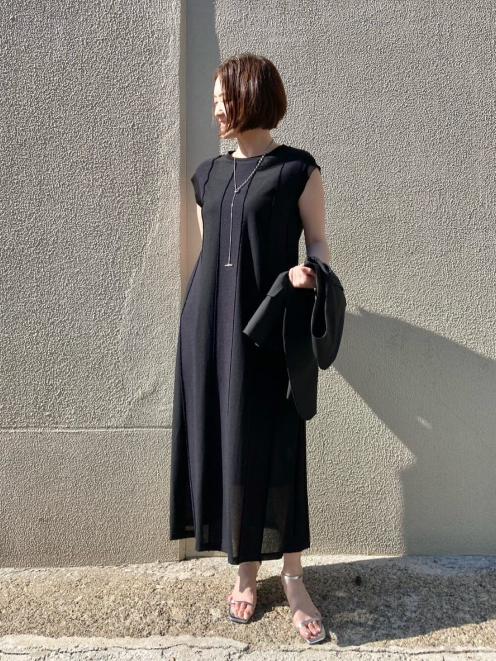 ブラック系のベストを着用したレディースの夏コーディネートの6枚目の写真