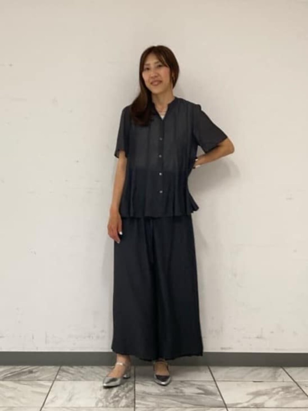グレー系のシャツ/ブラウス、ブラック系のその他パンツ、シルバー系のバングル/リストバンドを着用したレディースの春コーディネートの2枚目の写真