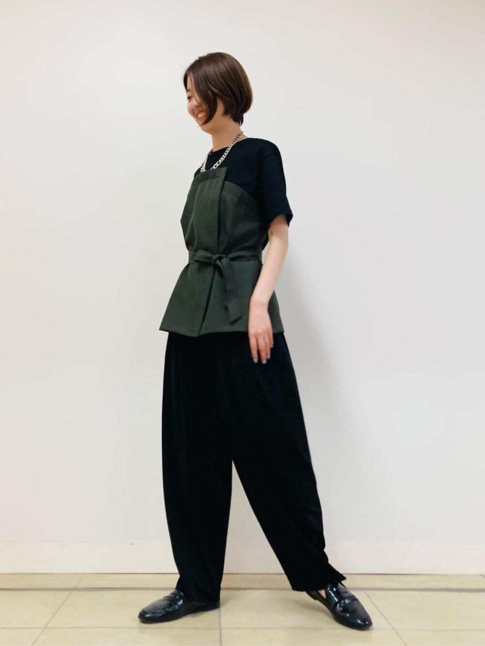 グリーン系のTシャツ/カットソー、ブラック系のパンツを着用したレディースの夏コーディネートの2枚目の写真