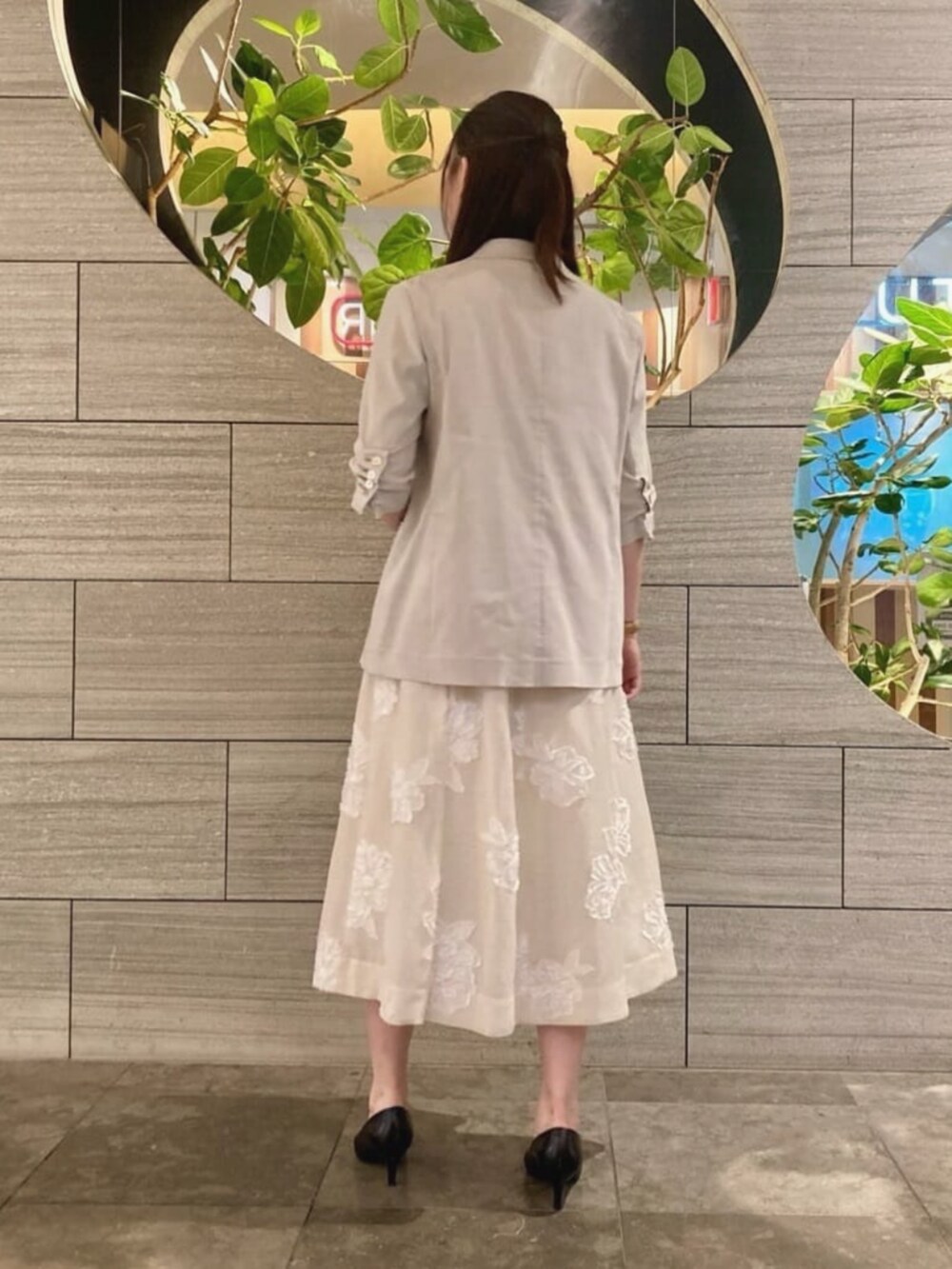 ベージュ系のテーラードジャケット、ベージュ系のワンピース、ホワイト系のネックレスを着用したレディースの夏コーディネートの3枚目の写真