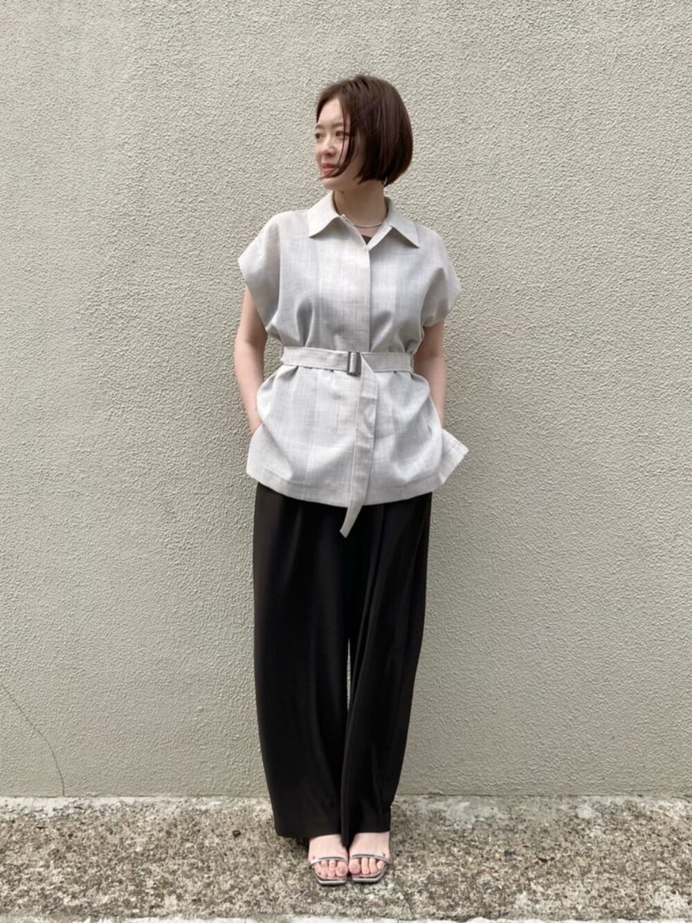 ブラウン系のキャミソール、ホワイト系のベスト、ブラウン系のパンツを着用したレディースの夏コーディネートの2枚目の写真