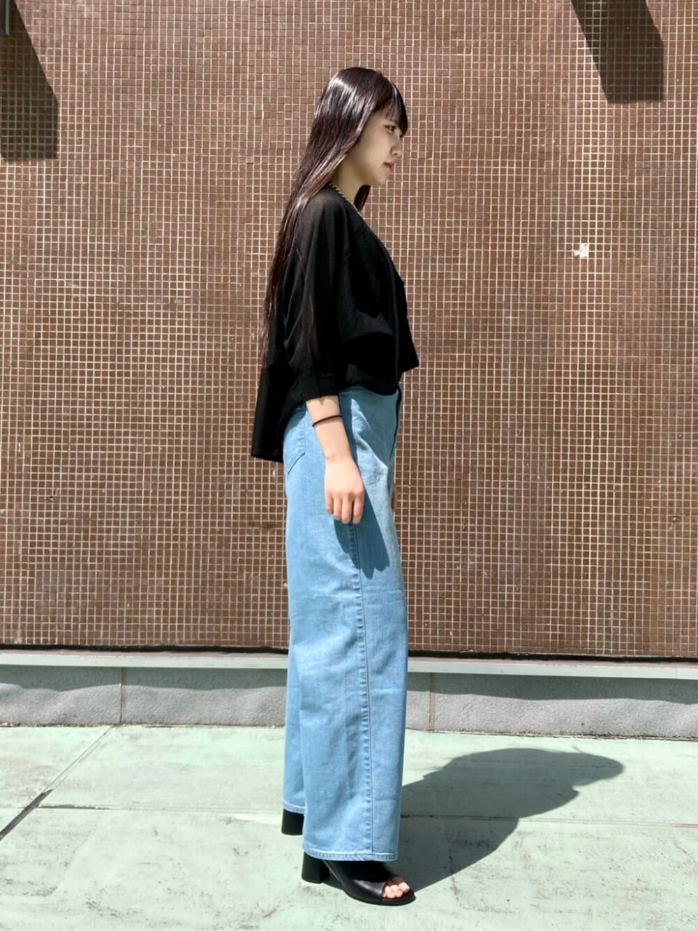 ブラック系のサンダル、ブルー系のタンクトップ、ブルー系のデニムパンツを着用したレディースの夏コーディネートの2枚目の写真