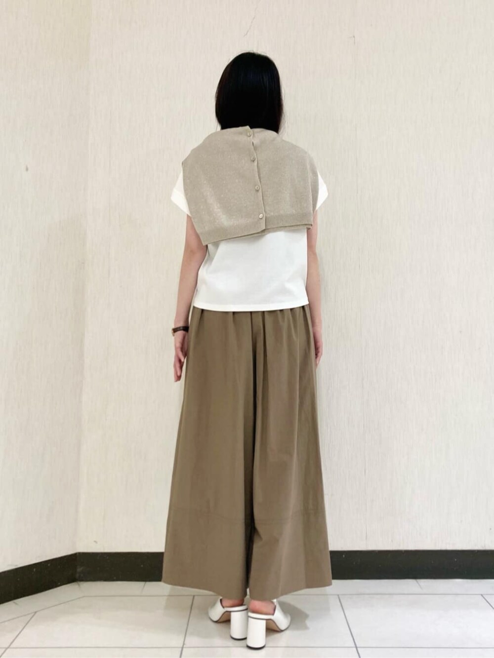 ベージュ系のカーディガン/ボレロ、ホワイト系のサンダル、ホワイト系のTシャツ/カットソーを着用したレディースの春コーディネートの5枚目の写真