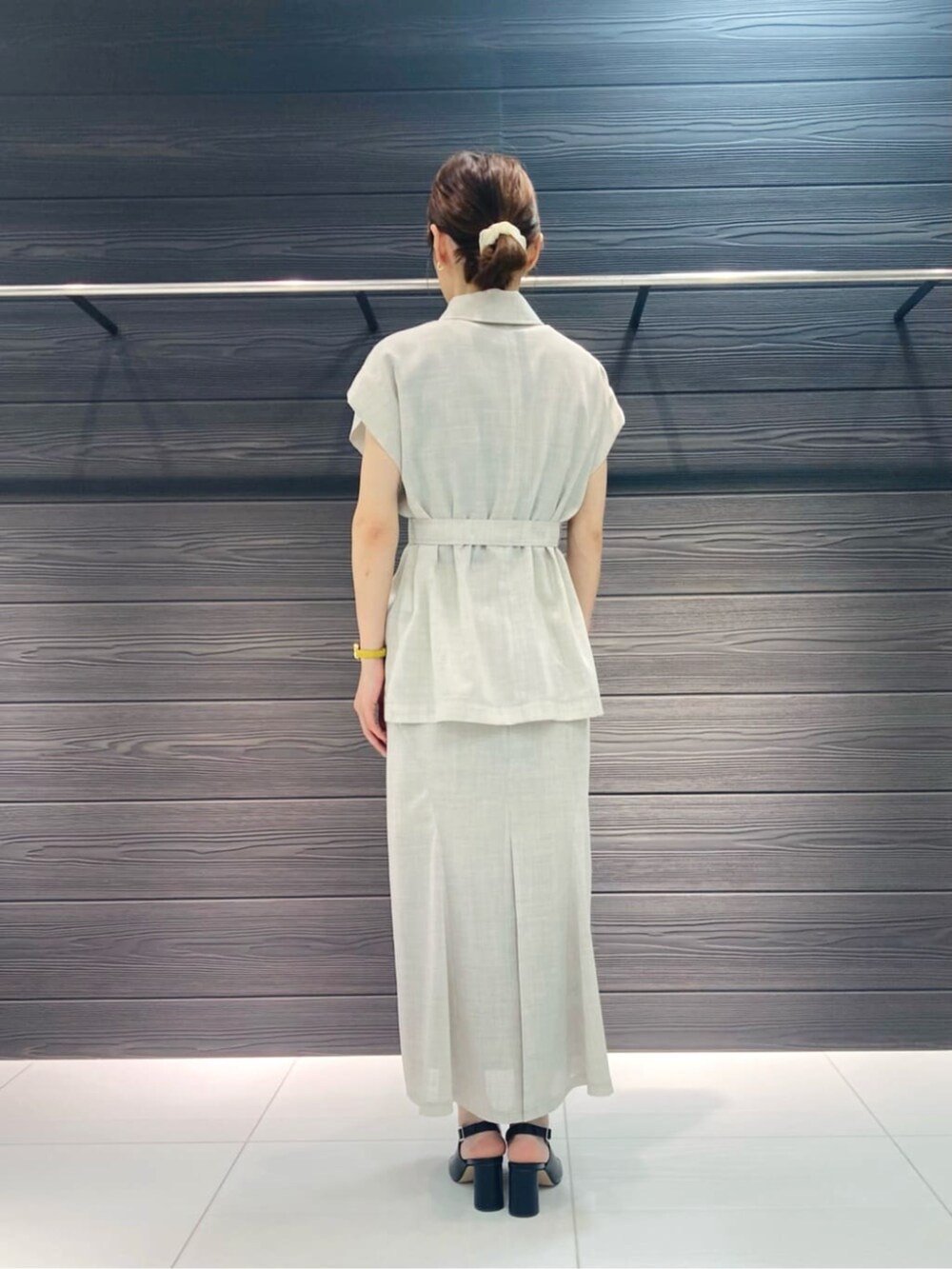 ブラック系のサンダル、ホワイト系のスカート、ホワイト系のベストを着用したレディースの夏コーディネートの3枚目の写真