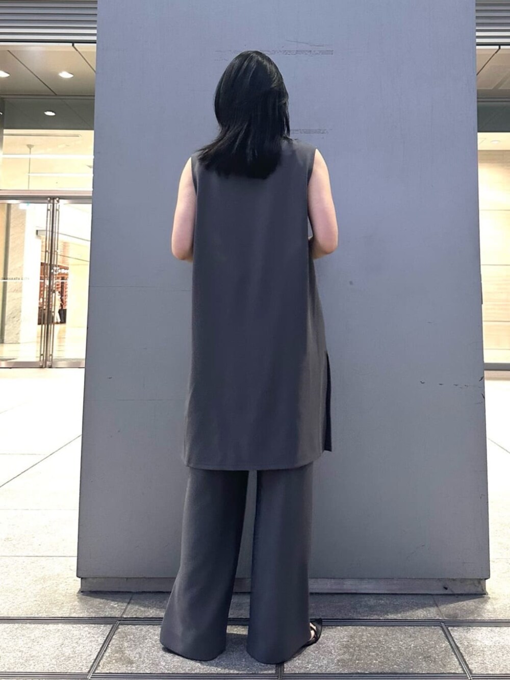 グレー系のベスト、グレー系のパンツを着用したレディースの夏コーディネートの3枚目の写真