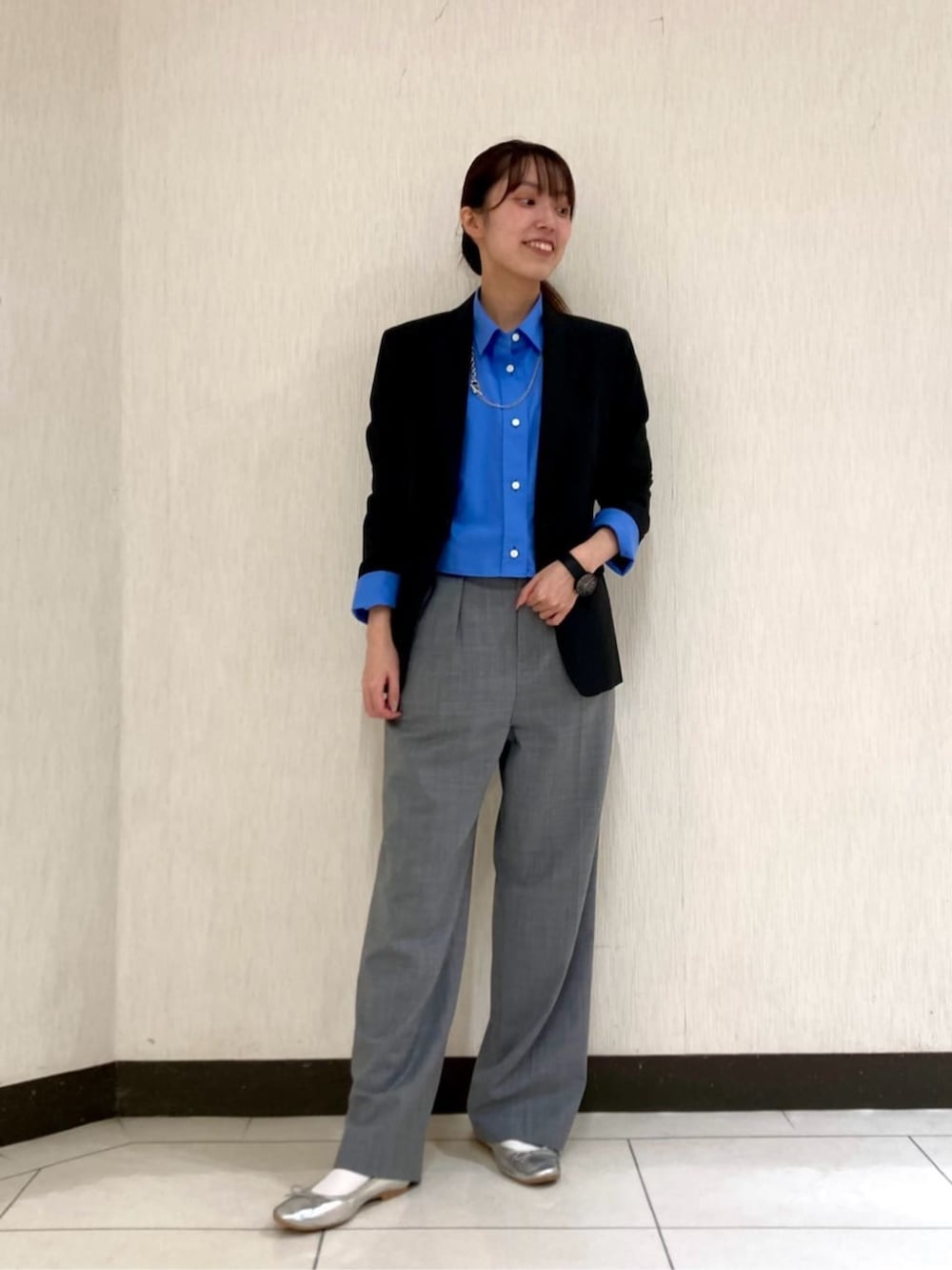 ブルー系のシャツ/ブラウス、グレー系のスーツパンツ、ブラック系のスーツジャケットを着用したレディースの秋コーディネートの2枚目の写真