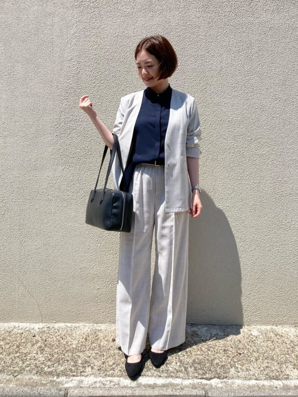 ブルー系のシャツ/ブラウス、ホワイト系のノーカラージャケット、ホワイト系のスラックスを着用したレディースの夏コーディネートの4枚目の写真