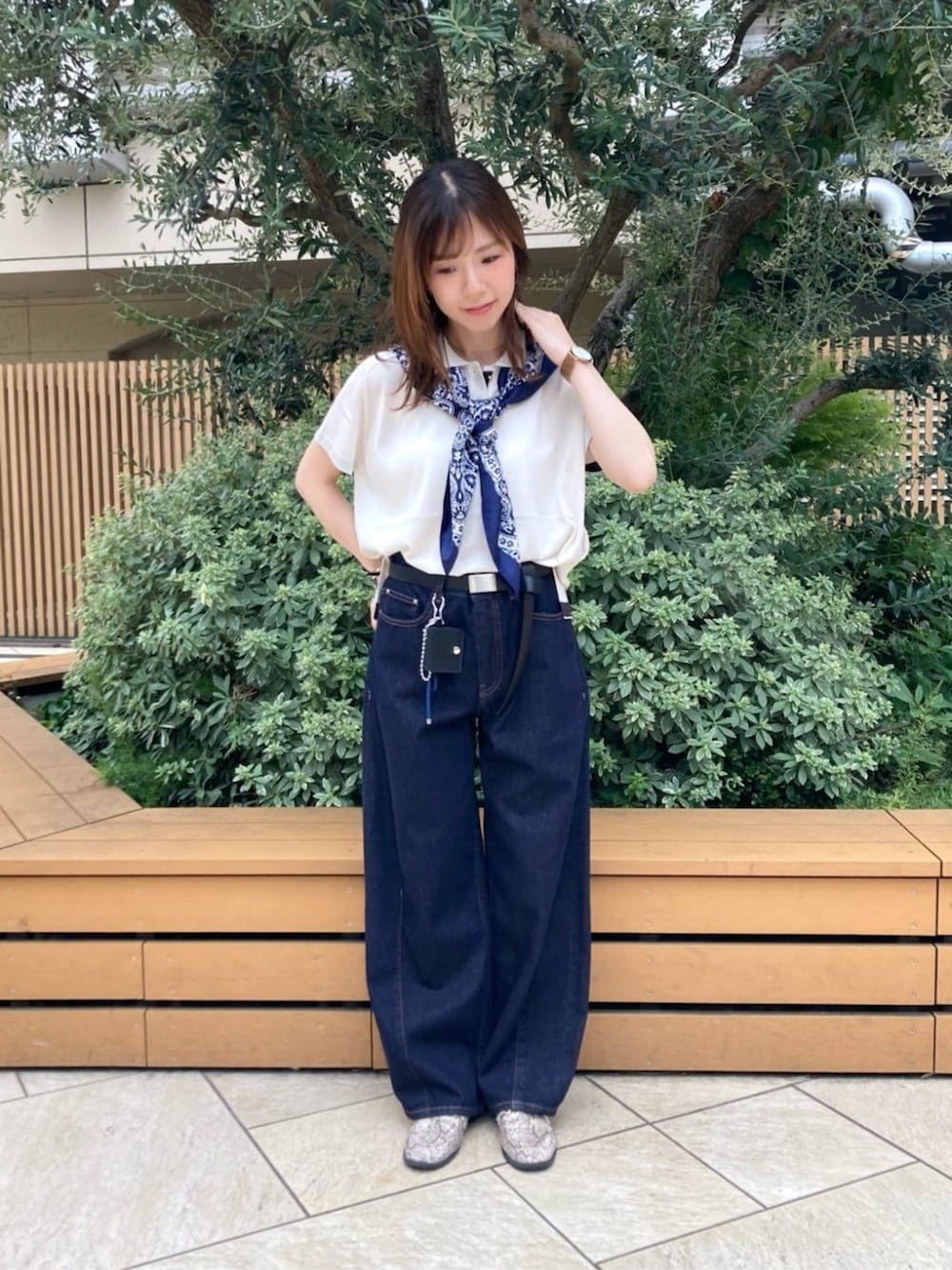 ブルー系のデニムパンツ、ホワイト系のニット/セーター、ブラック系のベルトを着用したレディースの夏コーディネートの2枚目の写真