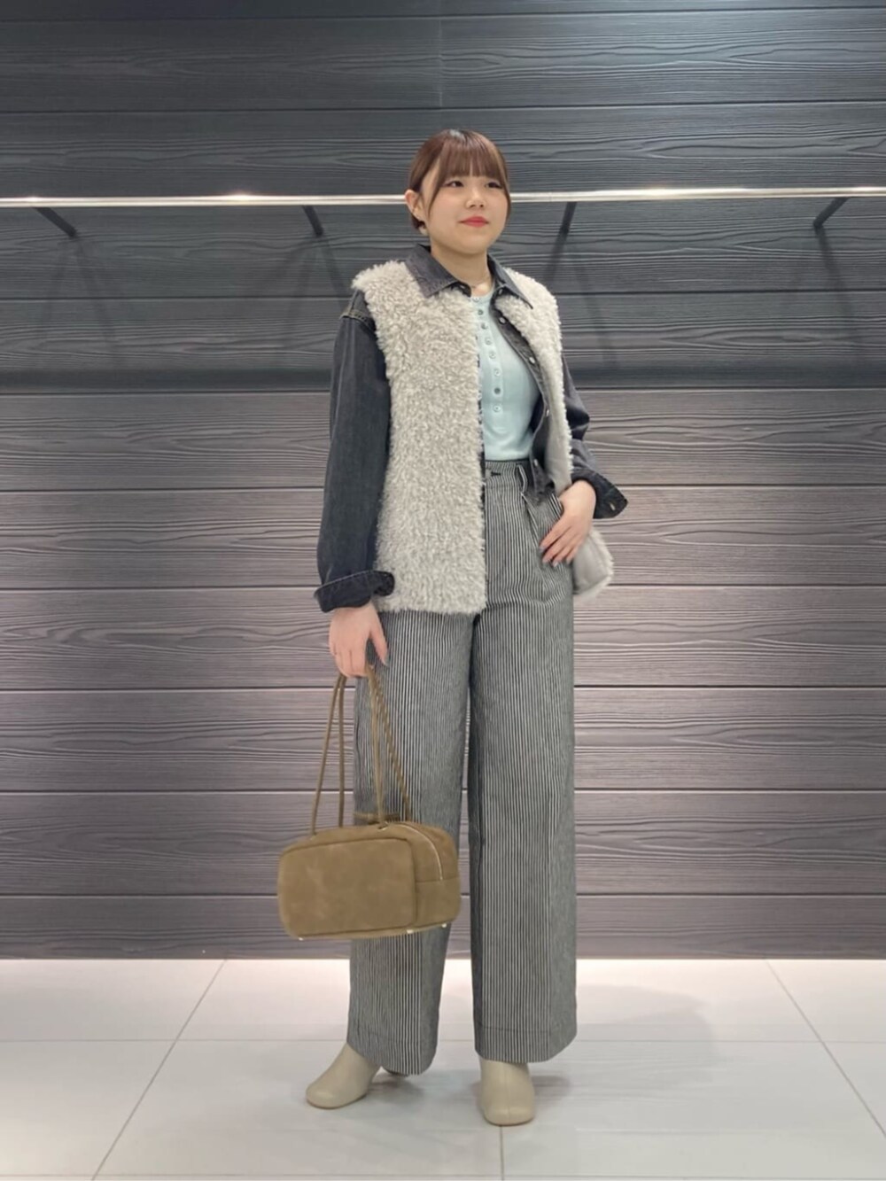 グレー系のベスト、ブラック系のその他パンツ、ブラック系のシャツ/ブラウスを着用したレディースの秋コーディネートの2枚目の写真