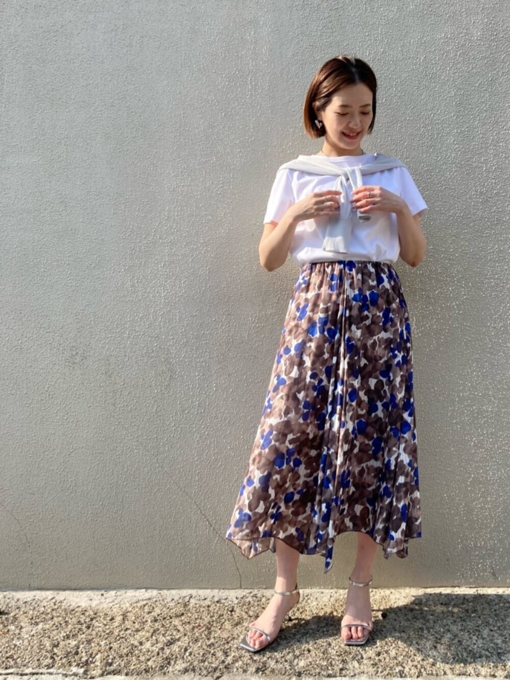 ブラウン系のスカート、ホワイト系のTシャツ/カットソー、グレー系のカーディガン/ボレロを着用したレディースの夏コーディネートの3枚目の写真