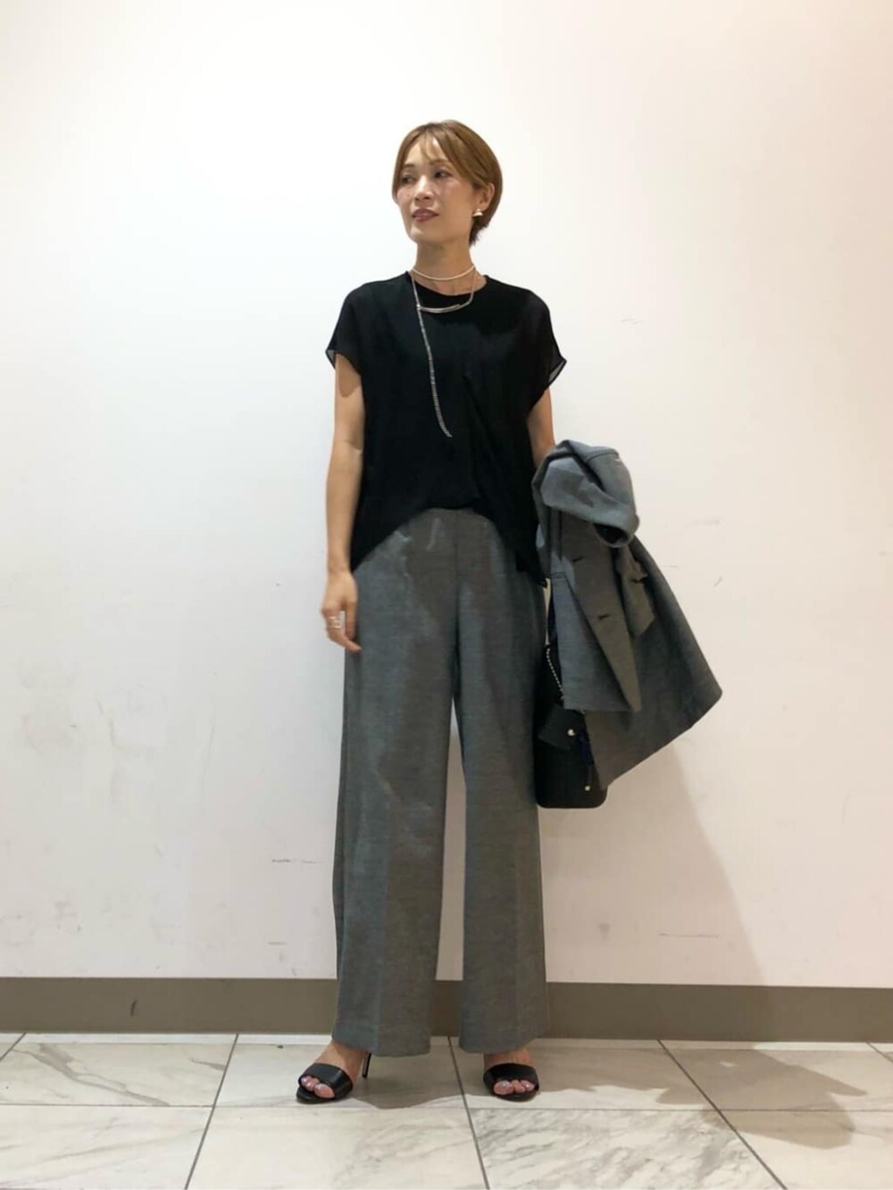 グレー系のテーラードジャケット、グレー系のその他パンツ、ブラック系のシャツ/ブラウスを着用したレディースの秋コーディネートの3枚目の写真