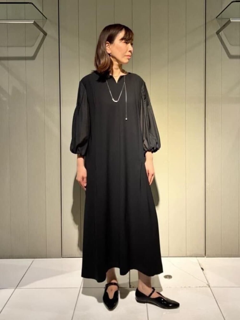 ベージュ系のノーカラージャケット、ブラック系のワンピース、ブラック系のパンプスを着用したレディースの冬コーディネートの5枚目の写真