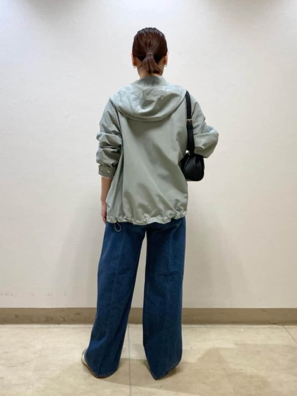 ブラック系のショルダーバッグ、グリーン系のパーカー、ピンク系のシャツ/ブラウスを着用したレディースの春コーディネートの5枚目の写真