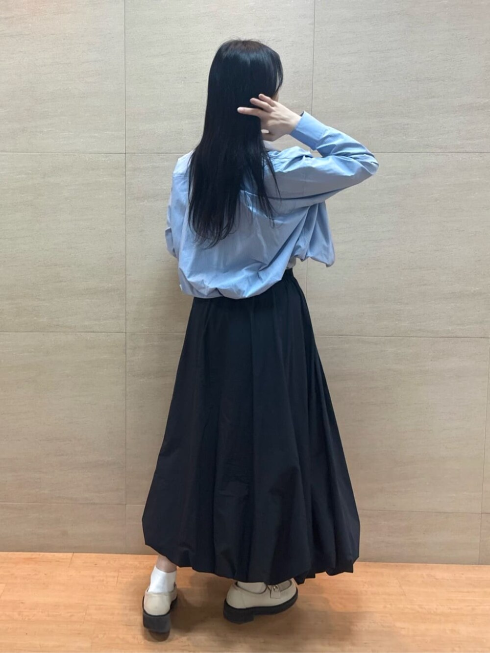 ブラック系のスカート、ブルー系のシャツ/ブラウス、シルバー系のタンクトップを着用したレディースの春コーディネートの4枚目の写真